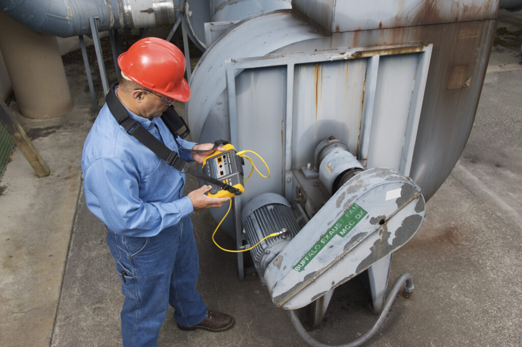 Imagem de operador realizando análise para evitar a vibração mecânica em motor elétrico.