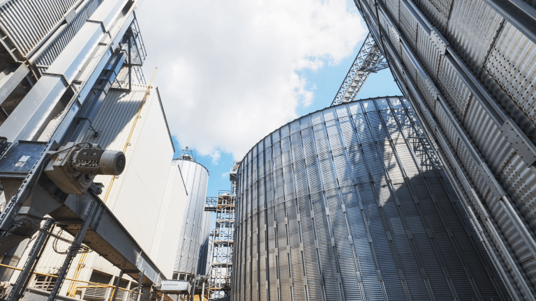 Silos e estruturas de armazenamento de grãos em planta agroindustrial, destacando a importância do setor produtivo no dia da indústria.