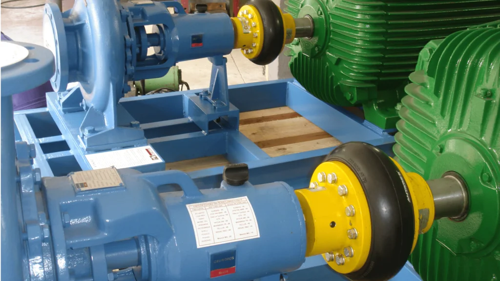 Acoplamento flexível de pneu conectando motor elétrico a bomba industrial, montado em base metálica para transmissão de torque.