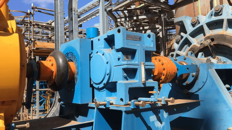 Conjunto de bomba de processo em operação, com acoplamento para bombas de processo ligado ao redutor e à bomba em ambiente industrial pesado.